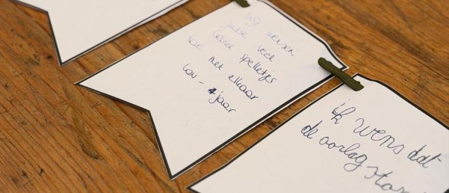 Slinger met wens 'Ik hoop dat de oorlog stopt' + 'Wij wensen jullie veel spelletjes en plezier' geschreven door twee kinderen op de Verenigingsmarkt in Overijse, 22/08/2026.
